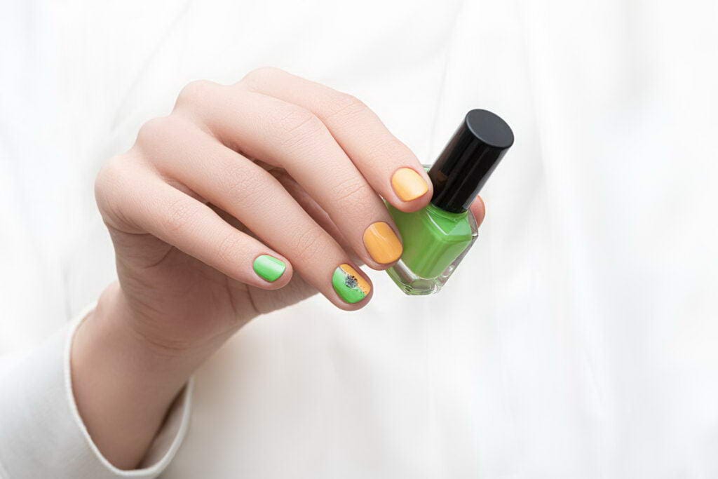 Green nail design. Female hand with dandelion nail art.